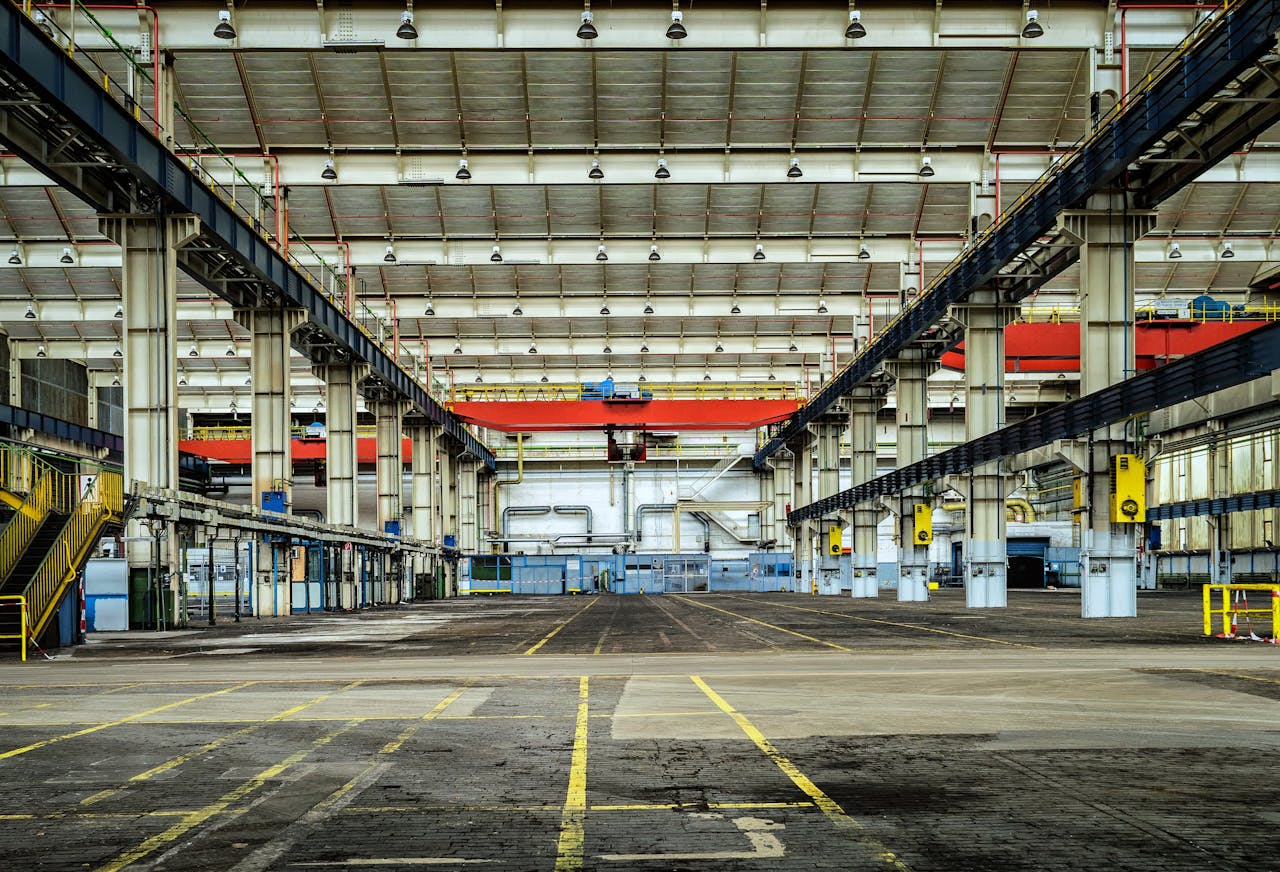 who-we-are Expansive industrial warehouse interior showcasing steel framework and spacious layout for diverse manufacturing needs.