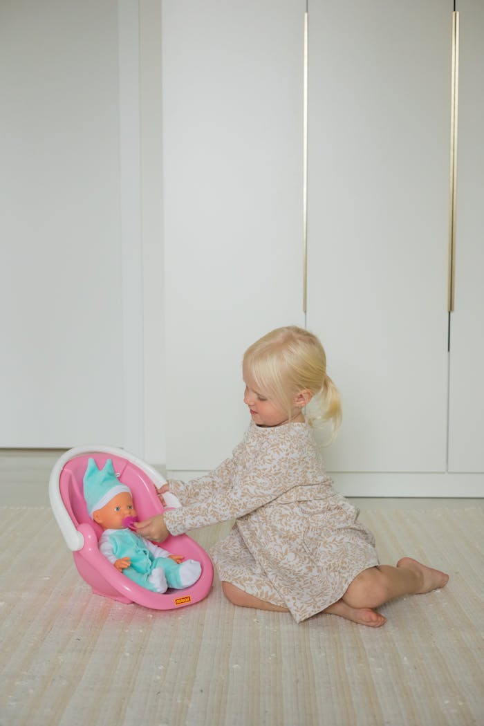 why-choose-us A young girl in a floral dress playing with a doll in a modern living room setting.